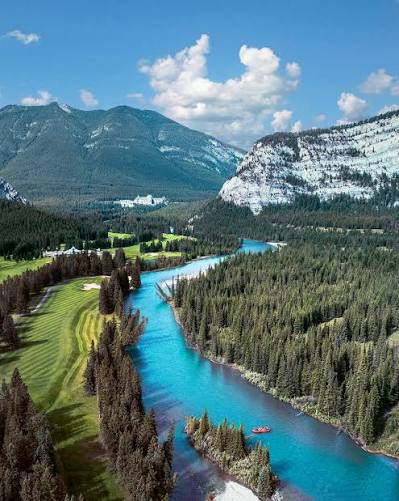 Aerial view of Banff golf course along a turquoise river with mountain peaks